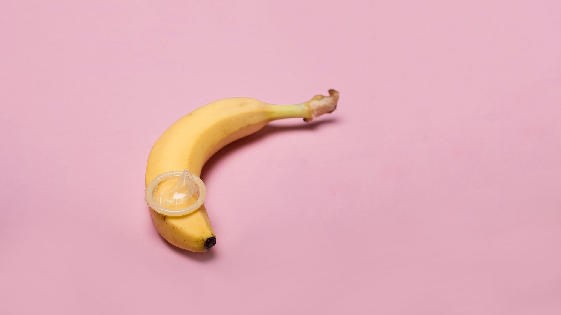 Toma de estudio de un plátano con un condón, simbolizando sexo seguro y concienciación sobre la anticoncepción.