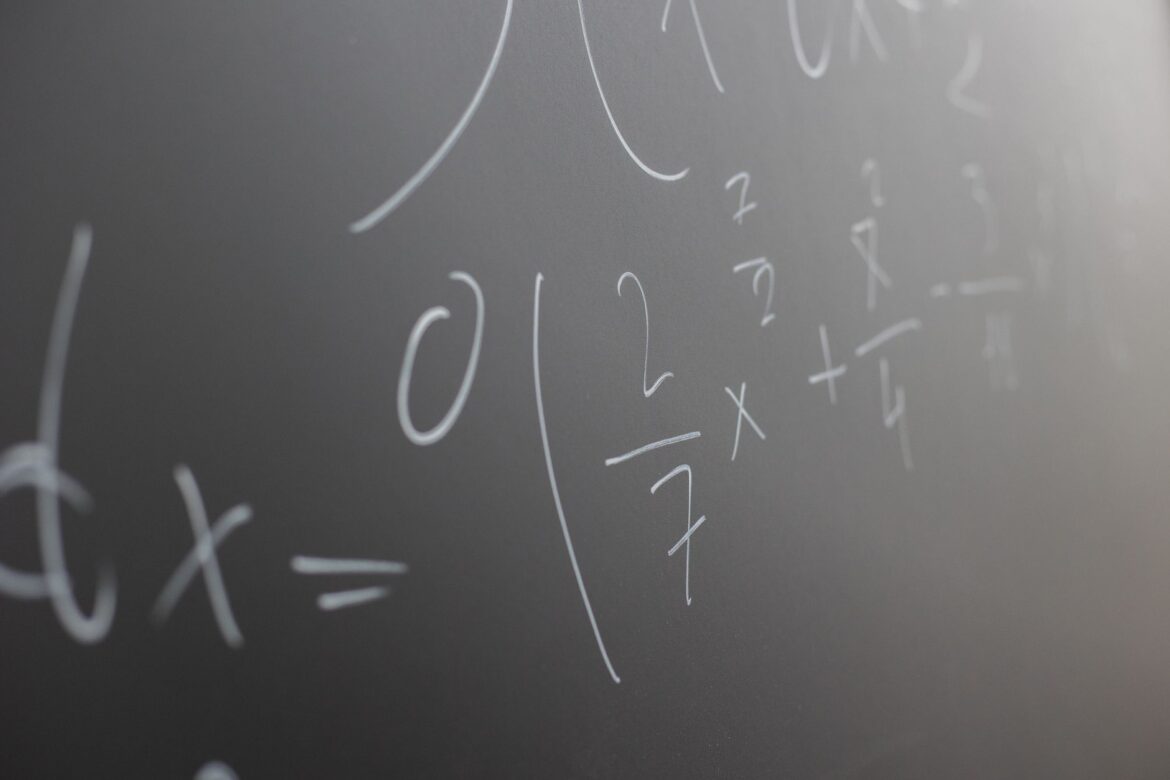 Vista detallada de ecuaciones matemáticas escritas en una pizarra con fines educativos.