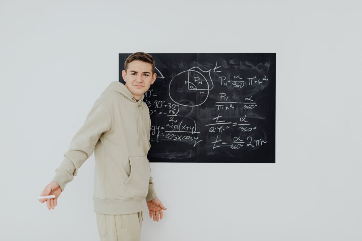Adolescente con ropa casual resolviendo ecuaciones matemáticas en una pizarra en el interior.