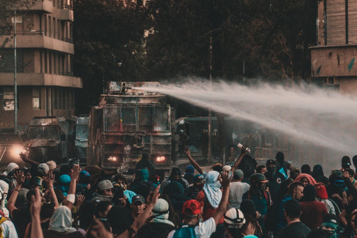 Una gran protesta en Santiago, Chile, con camiones de agua y una multitud de manifestantes.