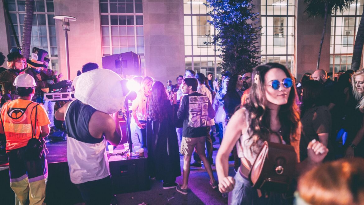 Fiesta al aire libre en Miami con una multitud enérgica y luces vívidas.